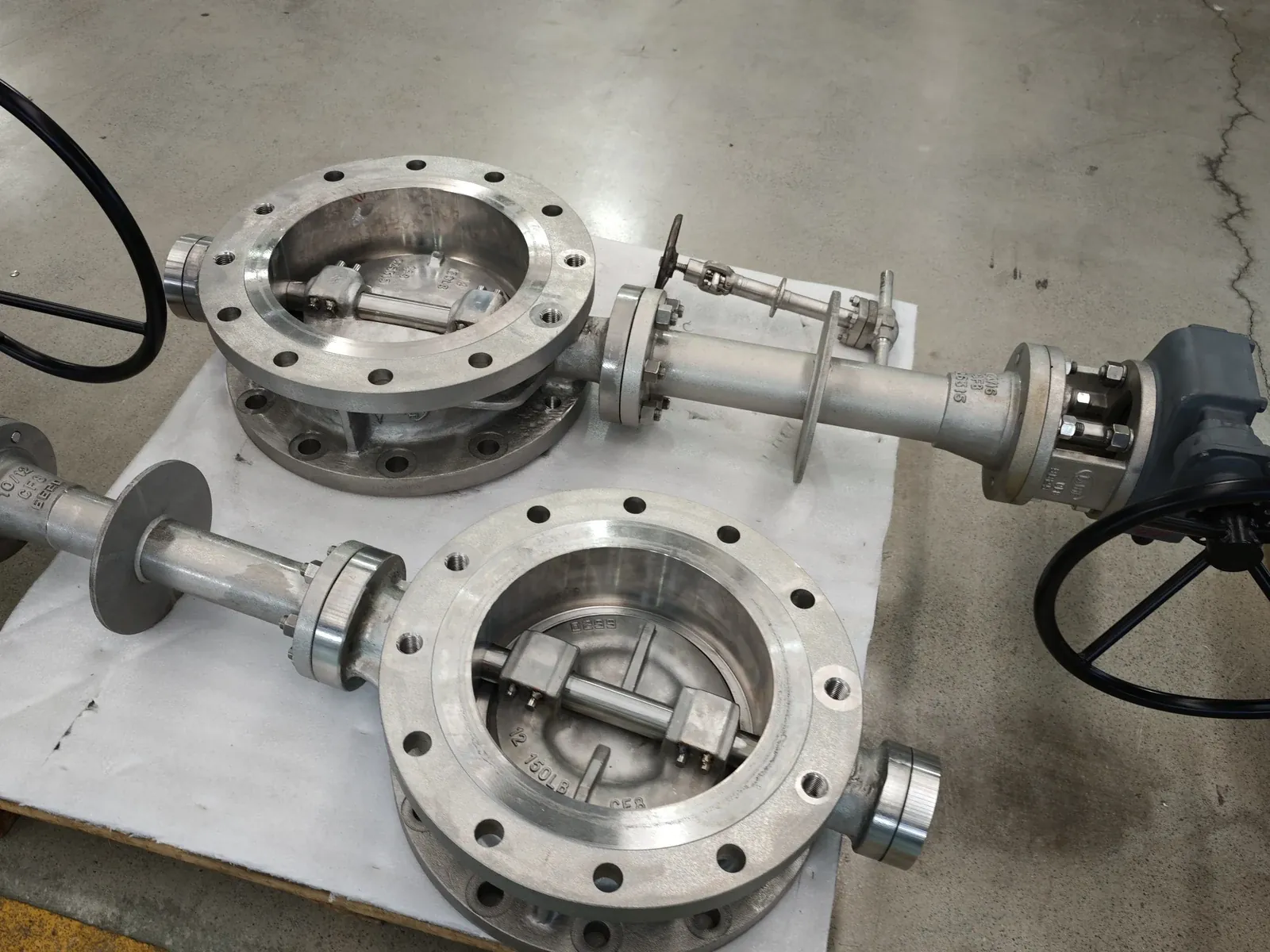Large-bore cryogenic butterfly and extended-bonnet gate valves on a shop-floor tray