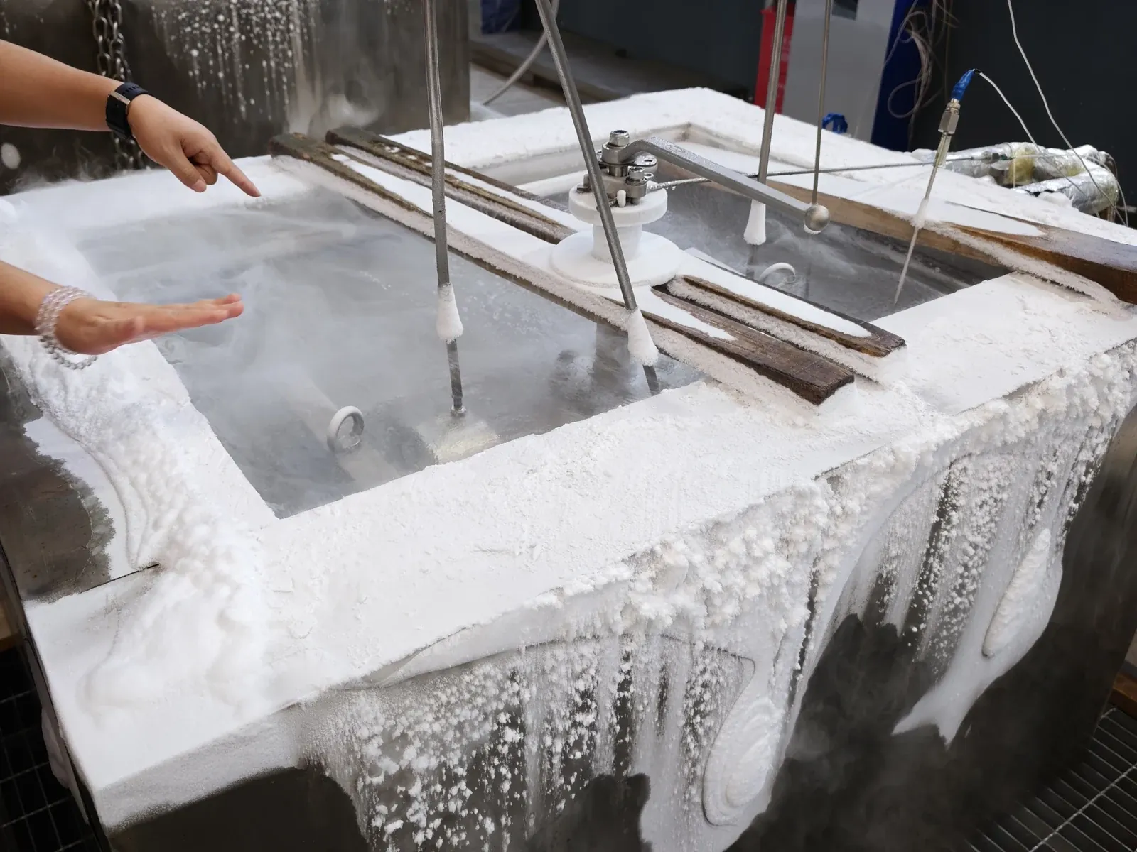 Operator pointing at a frosted valve inside the LN2 test bath